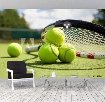 Picture of Tennis balls and racket on the grass court